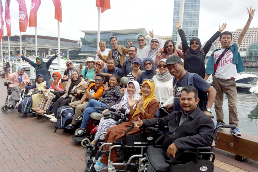 a group of smiling people waving hands